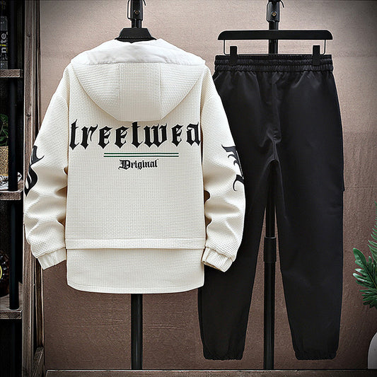 White hoodie with 'treetwear Original' text and black pants on hangers against a neutral background.
