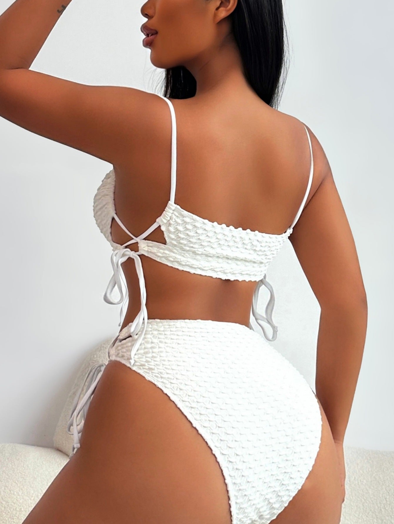 White bikini set worn by a model against a white background