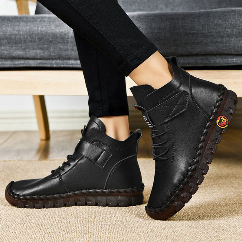 Black leather shoes worn indoors on a carpeted floor.