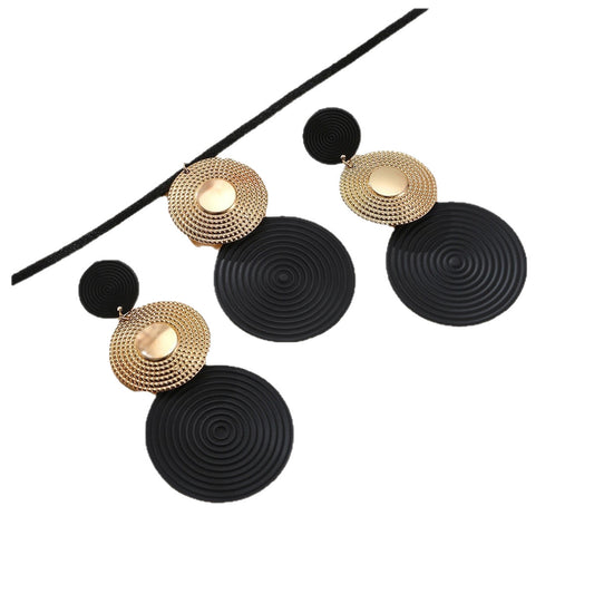 Pair of black and gold earrings on a white background
