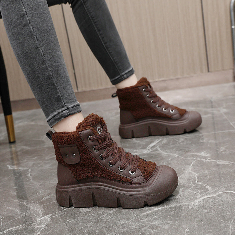 Brown winter boots with fur lining worn by a person on a marble floor.