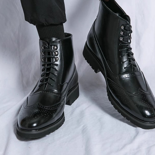 Black leather boots with a glossy finish on a white background