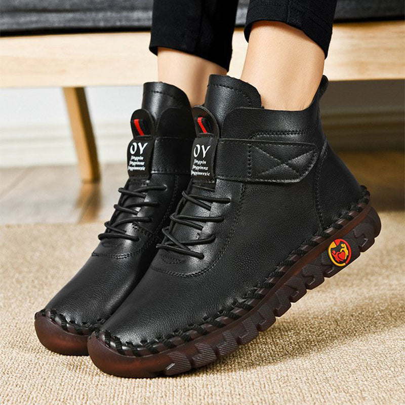Black leather boots with brand logo on a carpeted floor