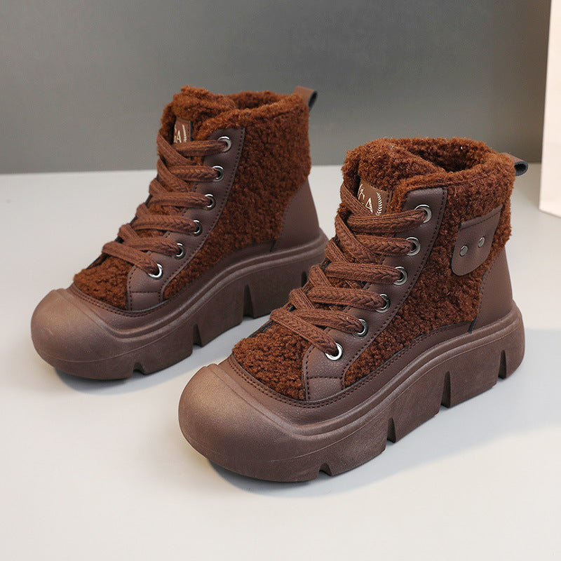 Pair of brown winter boots with fuzzy texture on a light gray background
