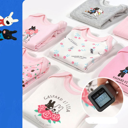 Baby clothing with brand logo and digital thermometer on a white background