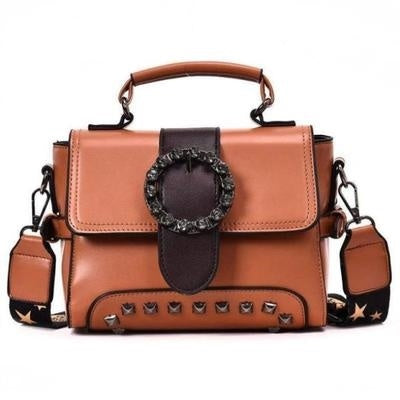 Brown handbag with decorative studded details on a white background