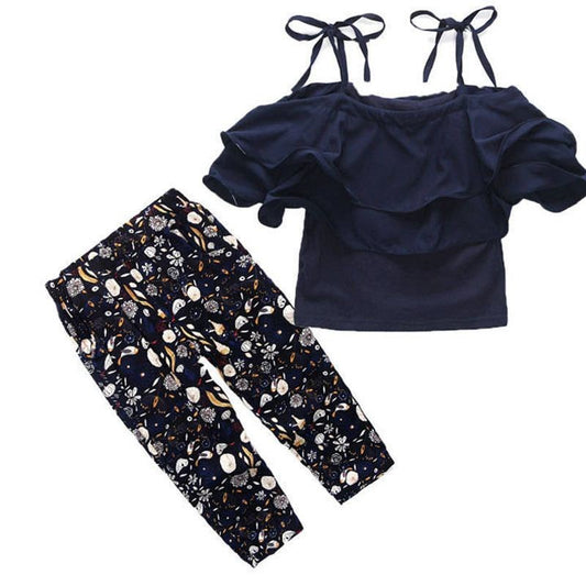 Navy blue top with ruffled shoulders and floral pants on a white background