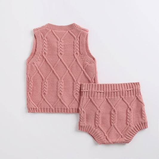 Pink knitted vest and bloomers set on a light gray background
