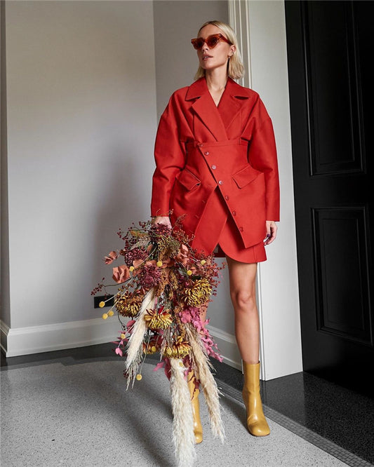Woman in a red coat holding dried flowers indoors. by millivan