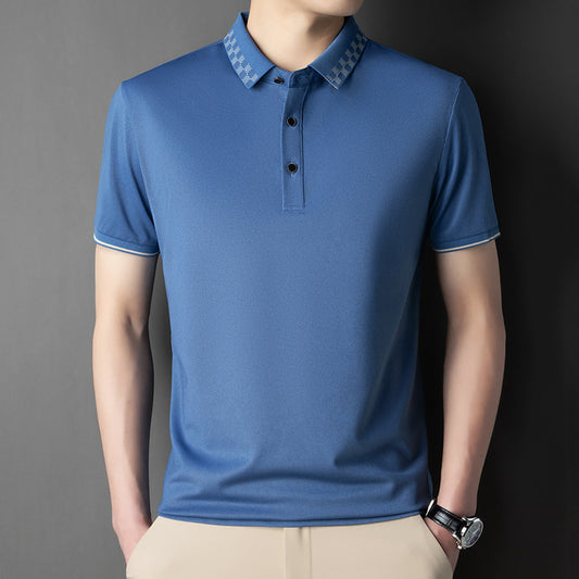 Person wearing a blue polo shirt with a gray background