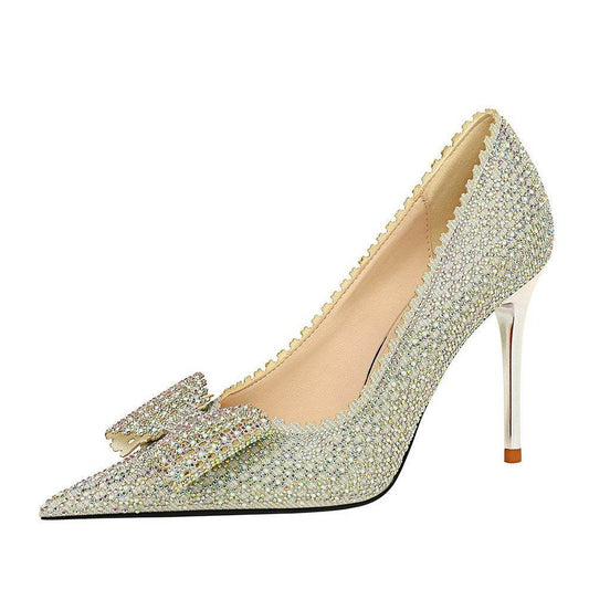 Sparkly high-heeled shoe with a bow on a white background