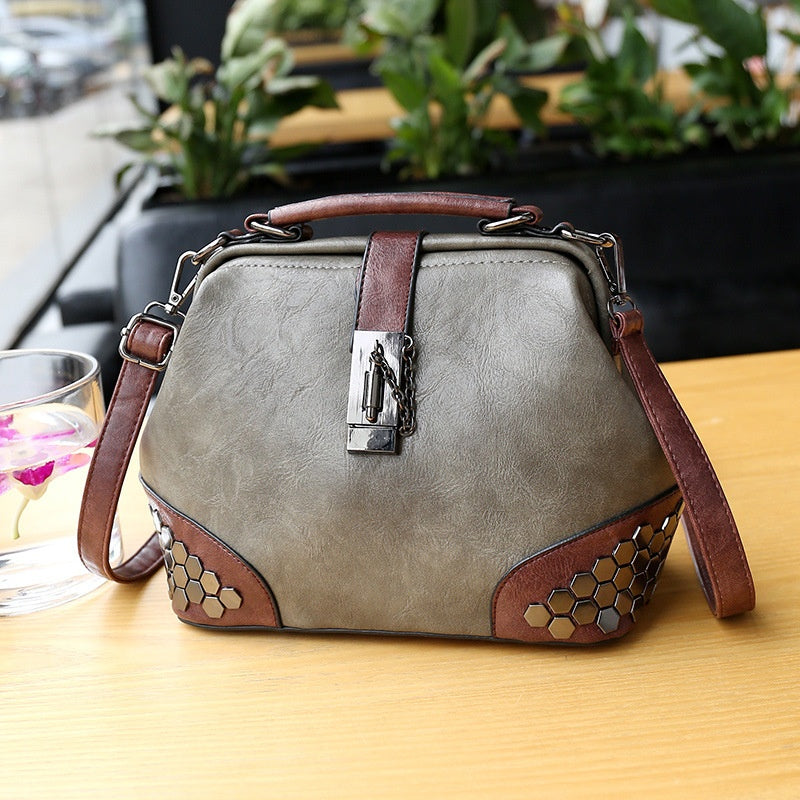 Gray handbag with brown accents on a wooden table