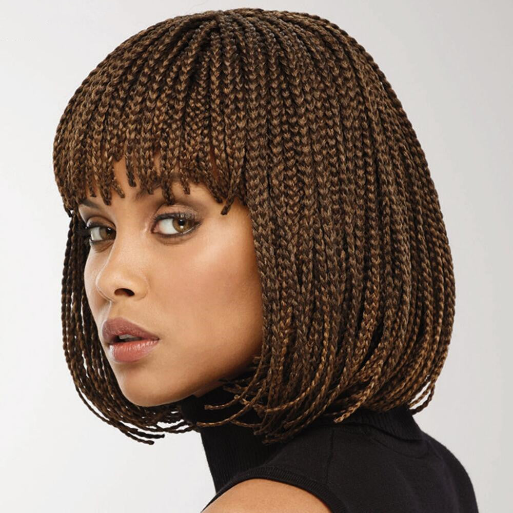 Woman with braided brown hair against a plain background