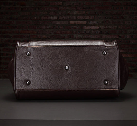 Brown leather bag with silver studs on a dark background