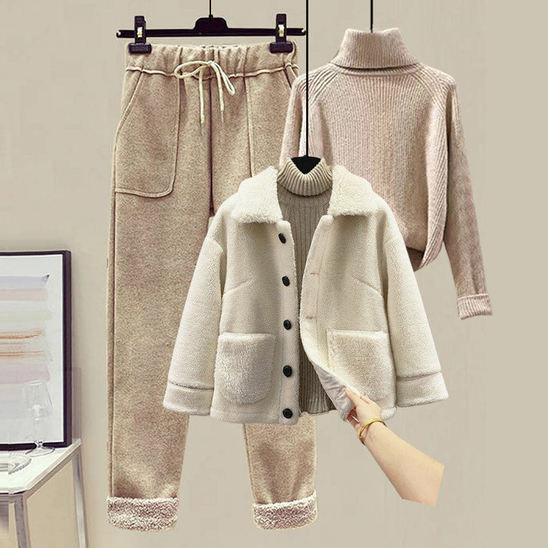 Winter clothing set with coat, pants, and sweater on a neutral background