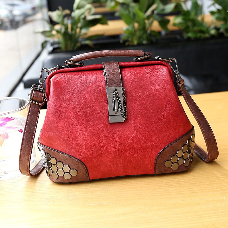 Red handbag with brown accents on a wooden surface