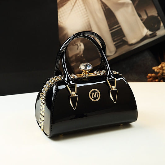 Black handbag with gold accents on a white surface