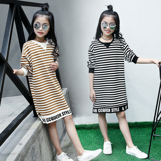Two children wearing striped dresses with 'COCCINELLE' branding on a gray background.