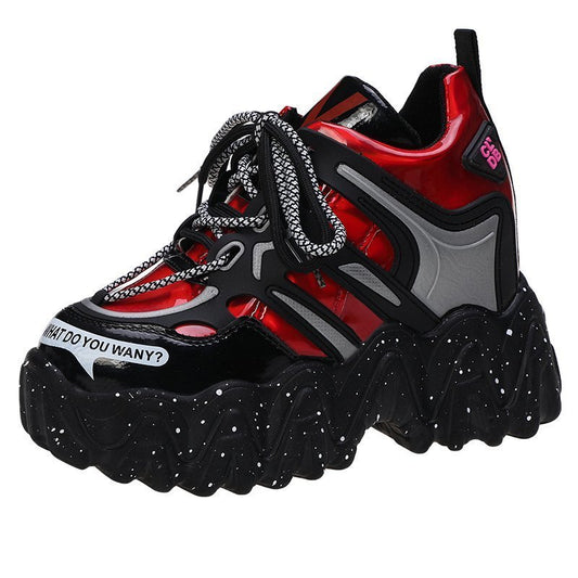 Black, red, and gray sneaker with chain detail on a white background