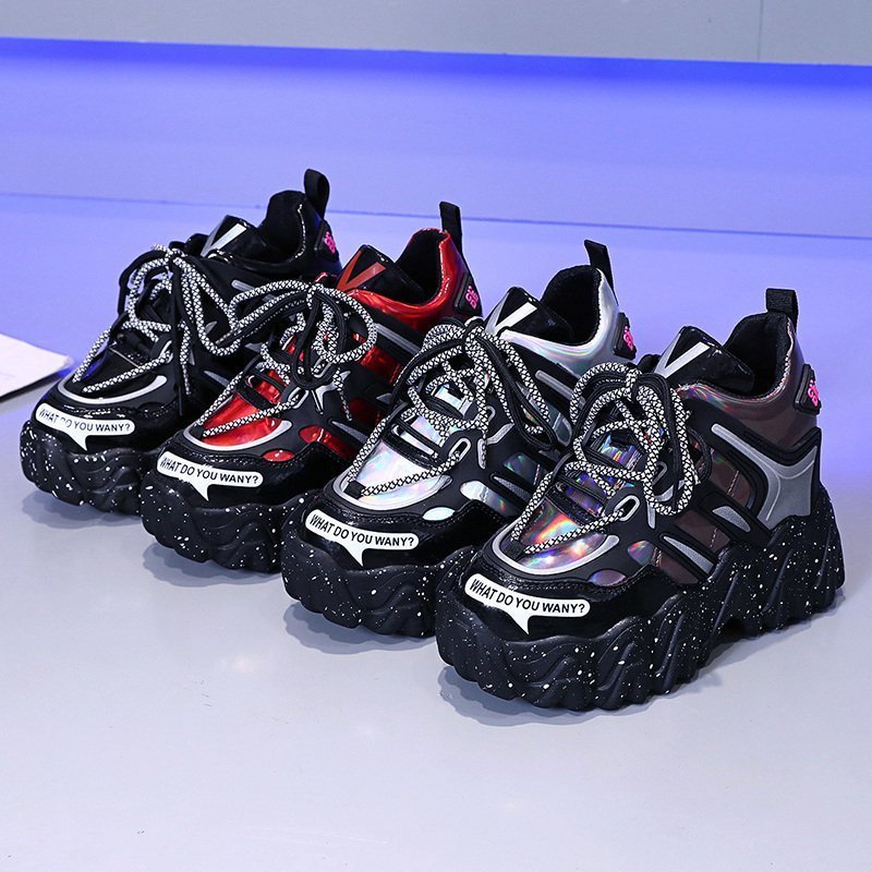 Black and white sneakers with colorful accents on a reflective surface.