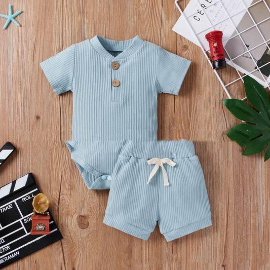 Light blue children's outfit with shorts on a wooden surface