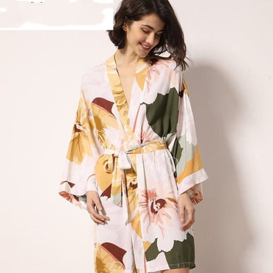 Woman wearing a floral kimono-style robe on a plain background