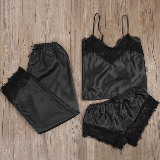 Black satin lingerie set with lace details on a wooden surface