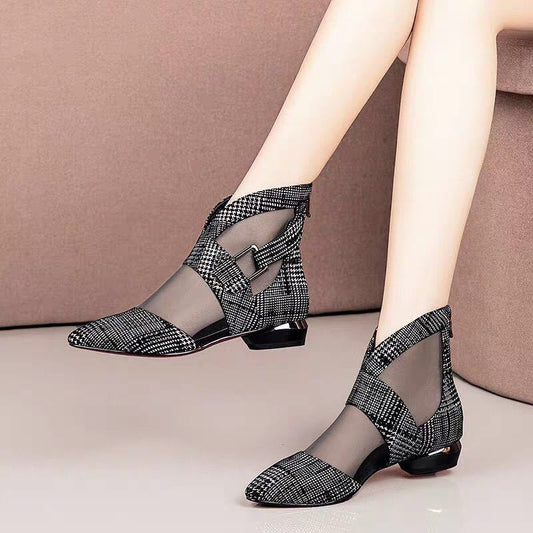 Black and white checkered shoes worn by a person on a neutral background