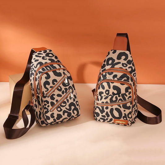 Two leopard print sling bags on a white surface with an orange background