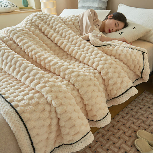 Person lying on a bed under a fluffy beige blanket in a cozy bedroom.