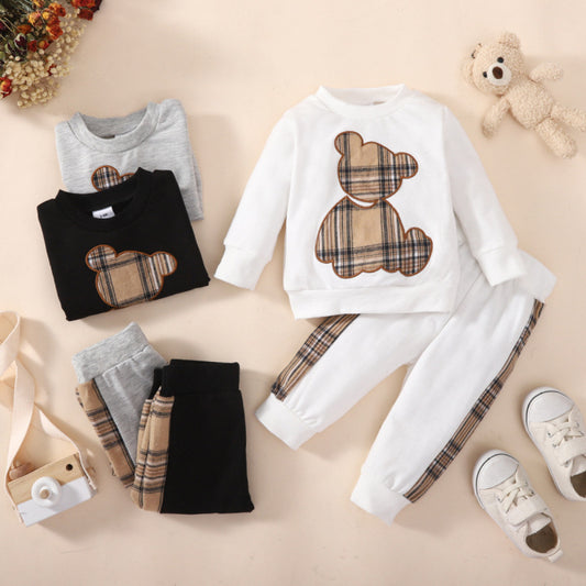 Children's clothing set with plaid bear design on a beige surface