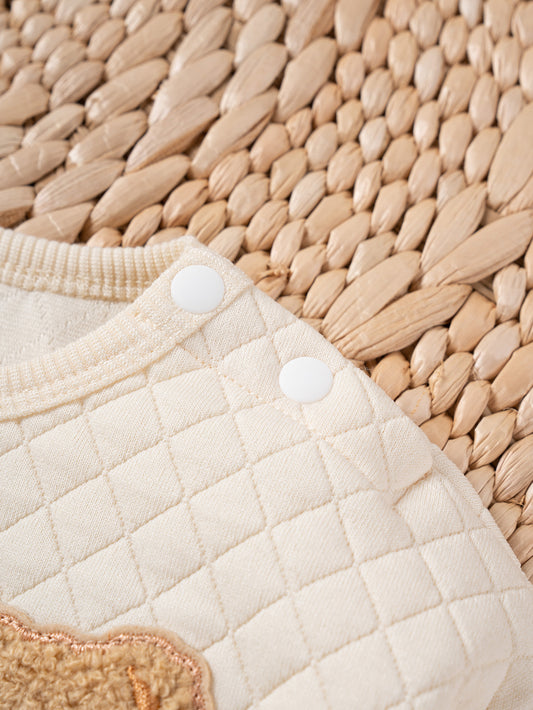 Close-up of a quilted beige fabric with a woven mat background