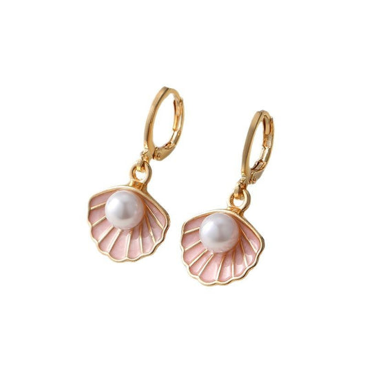 Gold earrings with pink shell designs and pearl centers on a white background