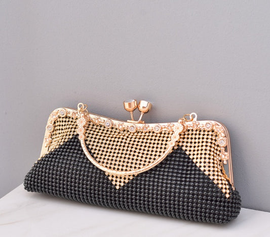 Black beaded clutch with gold frame on a gray background