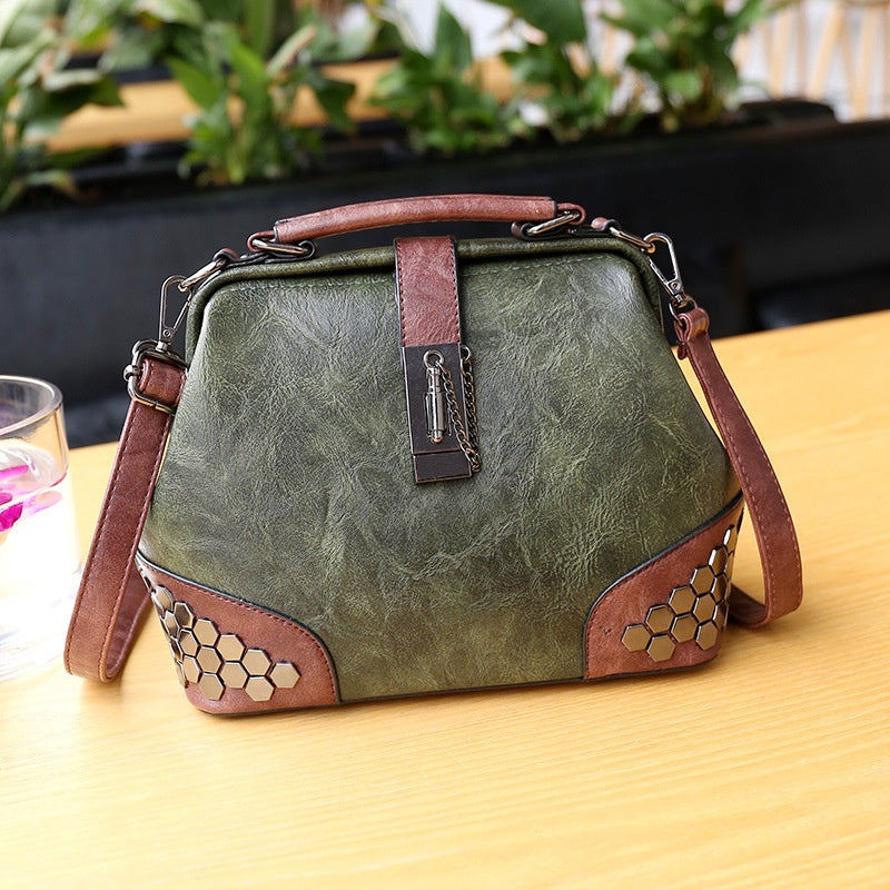 Green handbag with brown accents on a wooden surface