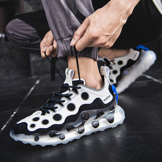 Person tying a black and white sneaker with visible brand logo on a dark floor.