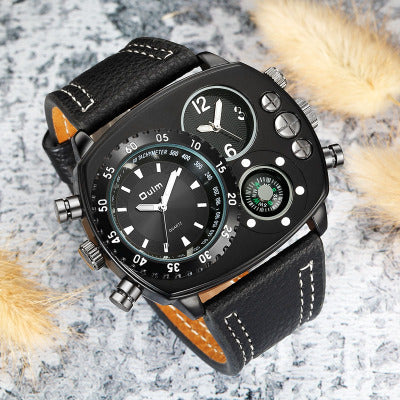 Black wristwatch with detailed face and leather strap on a textured surface