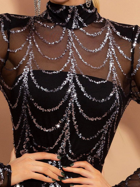 Black sequin top with spider web design on a beige background