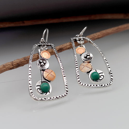 Pair of silver earrings with colored stones on a gray background