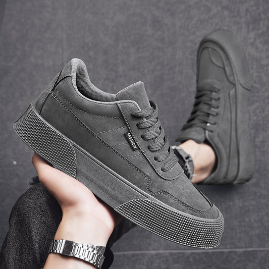 Gray sneaker held by a hand with a dark background