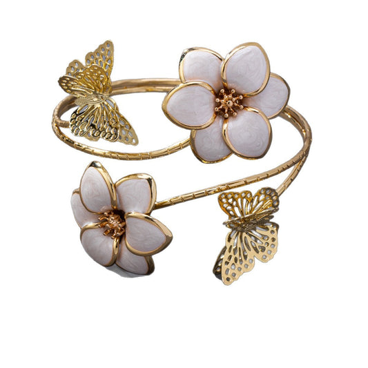 Gold bracelet with white flowers and butterflies on a white background