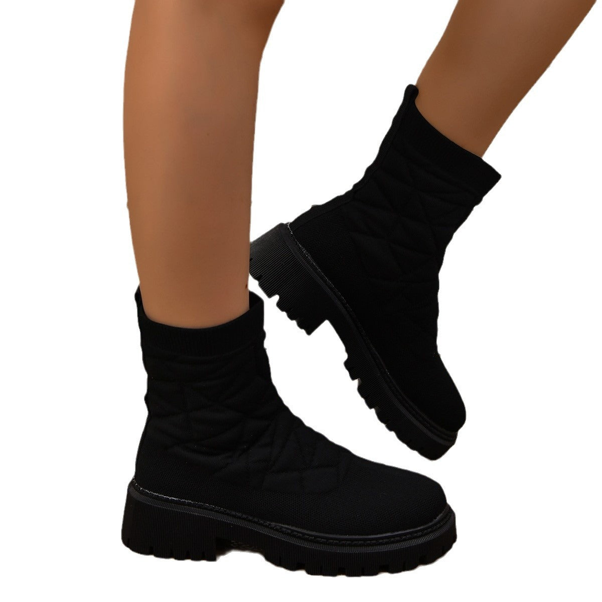 Black platform boots worn with black socks on a white background