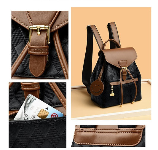 Black backpack with brown accents and a smiley face charm on a beige background