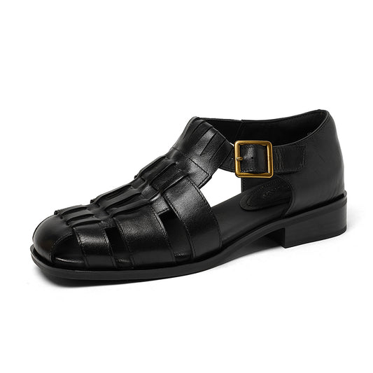 Black sandal with a gold buckle on a white background