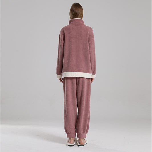 Person wearing a pink tracksuit against a plain background