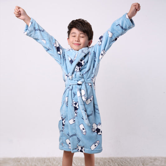 Child wearing a blue robe with cartoon designs against a white background