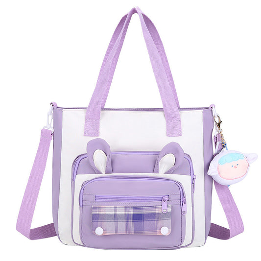 Purple and white handbag with plaid pocket and strap on a white background