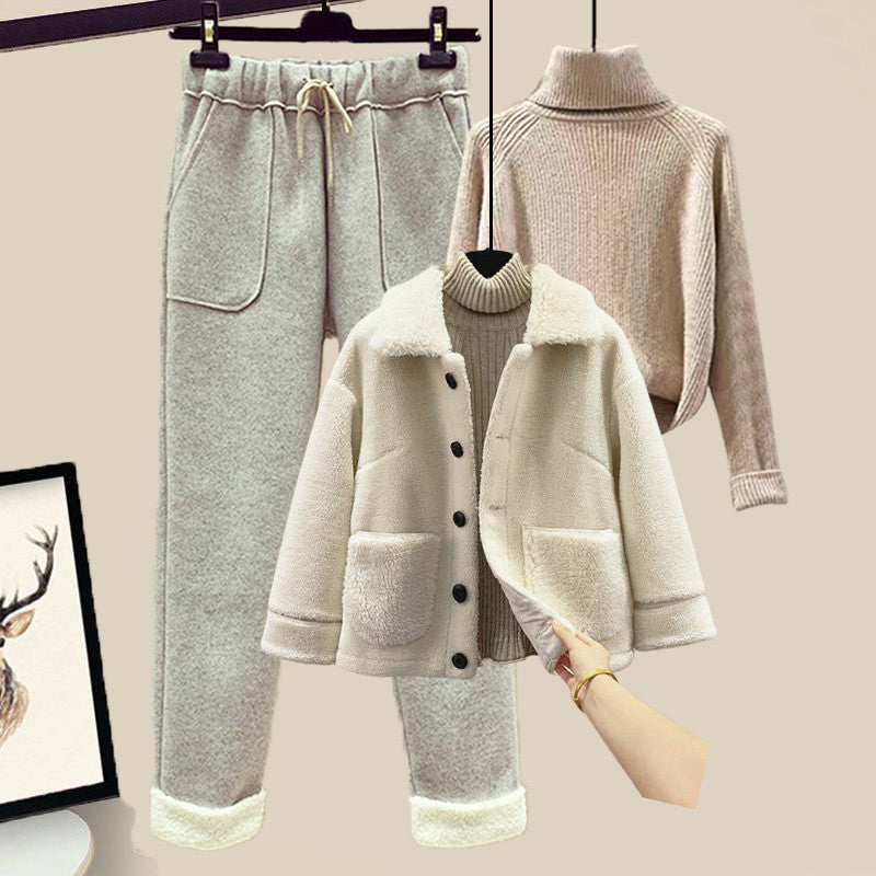 Set of clothing including a coat, pants, and sweater on a beige background