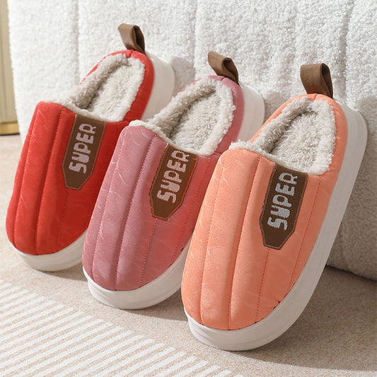 Pair of pink and red slippers with 'Super' label on a textured surface.
