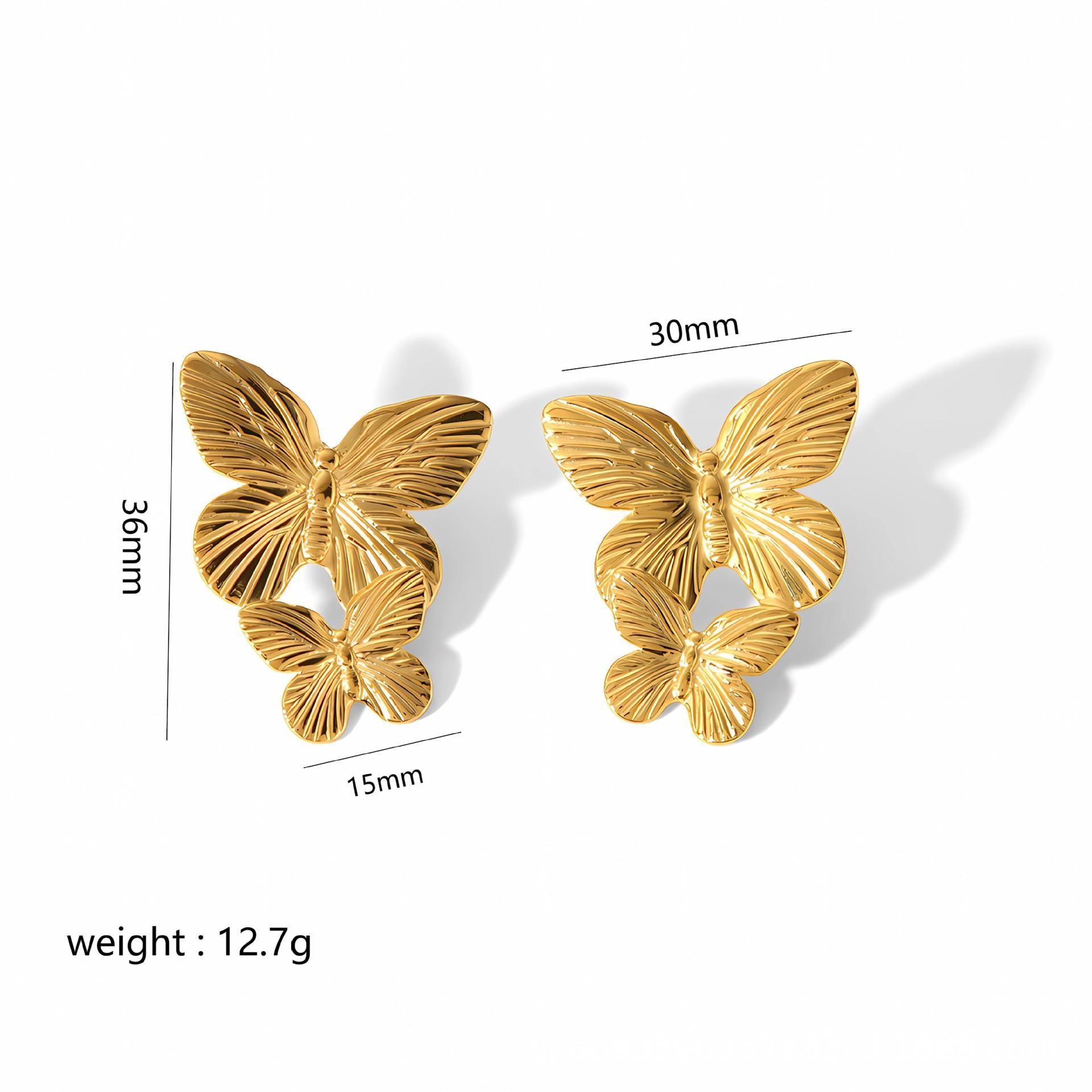 Gold butterfly earrings with measurements on a white background